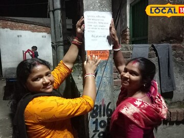 পোস্টার লাগাচ্ছেন মহিলারা