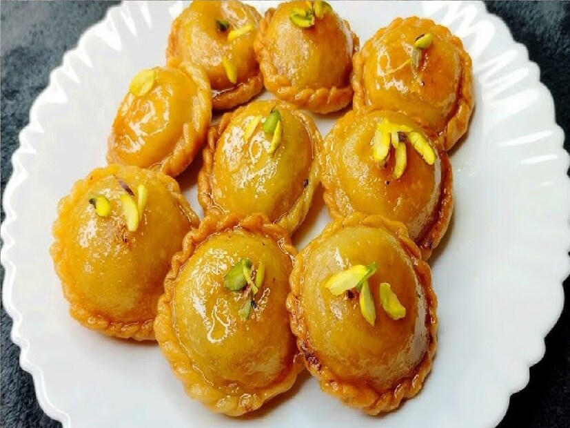 *এরপর চেপে চেপে সিল করে নেওয়ার পর একসঙ্গে পুরো লেচি ছোট ছোট ফোল্ড করে নিতে হবে। চাঁদের আকারে ফোল্ড করে নেওয়ার পর এরপর গরম ডুবো তেলে পুরি লেচিটি ভেজে নিতে হবে। লেচি চারপাশে ভালভাবে ভেজে লাল হয়ে যাওয়ার পর চিনি সিরায় ডুবিয়ে বের করে নেওয়ার পর তৈরি হয়ে যাবে আপনার পছন্দের চন্দ্রকলা মিষ্টি। তাই বাড়িতেই মিষ্টির দোকানের মতো সহজেই বানিয়ে ফেলুন চন্দ্রকলা। ফাইল ছবি।