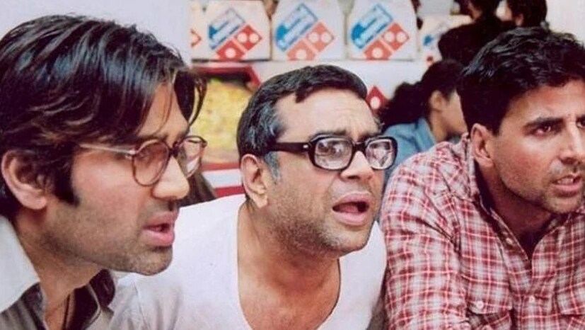 জানা যাচ্ছে, এই ছবিটি করার জন্য নাকি বাজারদরের থেকে ৩ গুণ টাকা বেশি নিয়েছিলেন পরেশ রাওয়াল। ছবিটির শ্যুটিং শুরু হওয়ার কথা ছিল ২০২৬ থেকে। অক্ষয়ের প্রোডাকশন হাউজের তরফে এ বার দাবি করা হয়েছে, প্রাথমিক ভাবে (অগ্রিম) তাঁর চরিত্রের জন্য ১১ লক্ষ টাকার চেক নিয়েছিলেন পরেশ। প্রমোশনাল ভিডিও শুটেও তিনি অংশ নেন। তার পরে সরে দাঁড়ানোর সিদ্ধান্ত জানান। (Photo: Still From Movie Hera Pheri)