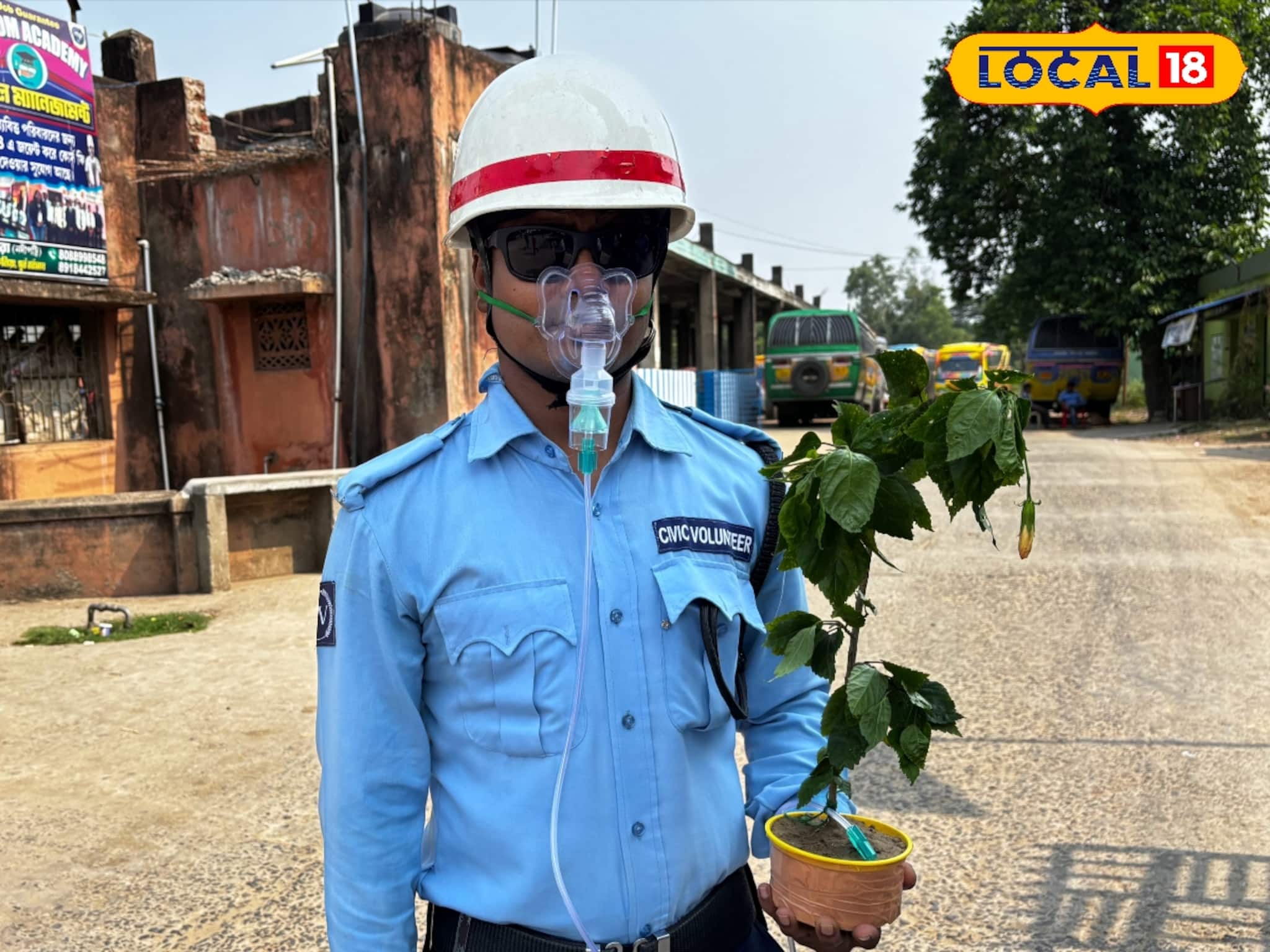 মুখে অক্সিজেন মাস্ক, হাতে চারা গাছ, এভাবেই ট্রাফিক সামলাচ্ছেন সিভিক ভলেন্টিয়ার, কারণটা কী?