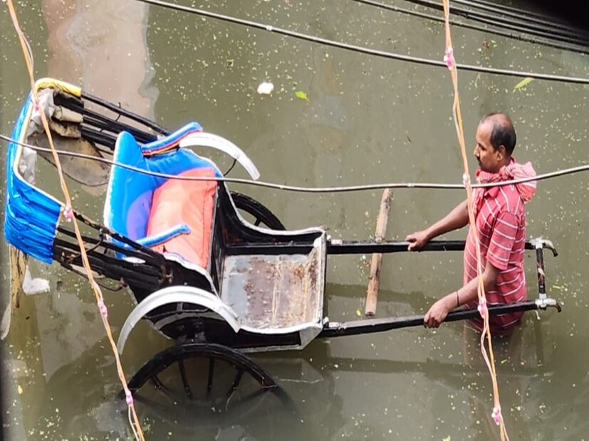 সোমবার রাতভর বৃষ্টিতে নাস্তানাবুদ কলকাতা। তিলোত্তমার একাধিক অংশ এখনও জলমগ্ন। জলে ভাসছে দক্ষিণ কলকাতার বালিগঞ্জের কর্নফিল রোড এলাকা। মঙ্গলবার CESC কর্মীকে ঘিরে কর্নফিল রোড-এ প্রতিবাদ-বিক্ষোভে ফেটে পড়েন স্থানীয়রা । সোমবার থেকে টানা বিদ্যুৎহীন এলাকা। বাড়িতে খাবার জলটুকুও নেই। কোথাও হাঁটু, কোথাও কোমর সমান জল। সেই জল পেরিয়ে কোনও ডেলিভারি সংস্থা 'প্যাকেজড' খাবার জল পৌঁছে দিতে নারাজ। বাধ্য হয়েই, রাস্তার কল থেকে ভরতে হচ্ছে খাবার জল। চরম ভোগান্তিতে দিশেহারা দক্ষিণ কলকাতার কর্নফিল রোডের বাসিন্দারা। CESC-র এক কর্মী মিটার রিডিং-এর জন্য আসলে তাঁকে ঘিরে এলাকাবাসীরা প্রতিবাদ জানান।