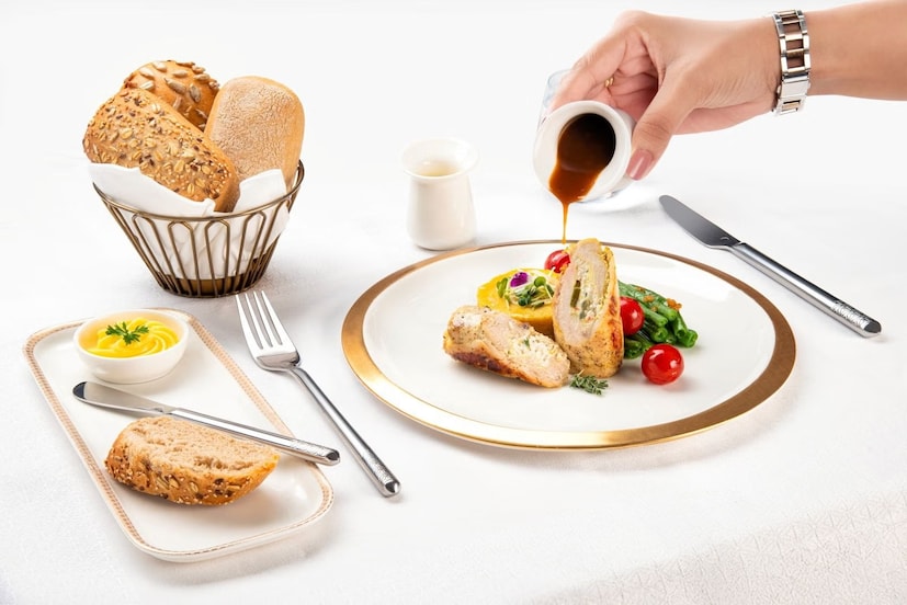 যাত্রীরা আন্তর্জাতিক খাবার, ঘরোয়া খাবার এবং সমসাময়িক স্বাস্থ্য-কেন্দ্রিক বিকল্পগুলির মধ্যে থেকে নিজের ইচ্ছামতো পদ বেছে নিতে পারবেন। শেফ সন্দীপ কালরার তৈরি মেনুর মধ্যে বিশেষ করে উল্লেখের দাবি রাখে আওয়াধি পনির আঞ্জির পসন্দা (ভেজ অওয়াধি থালি) এবং মালাবার চিকেন কারির (Malabari Chicken Curry) মতো সিগনেচার ভারতীয় পদ, পাশাপাশি জাপানি টেপ্পানিয়াকি বোল (Japanese Teppanyaki Bowl), ম্যানিকোটি ফরেস্টিয়ের এবং ভূমধ্যসাগরীয় ট্যাপাসের মতো বিশ্বব্যাপী প্রসিদ্ধ পদ। (Photo: Air India)