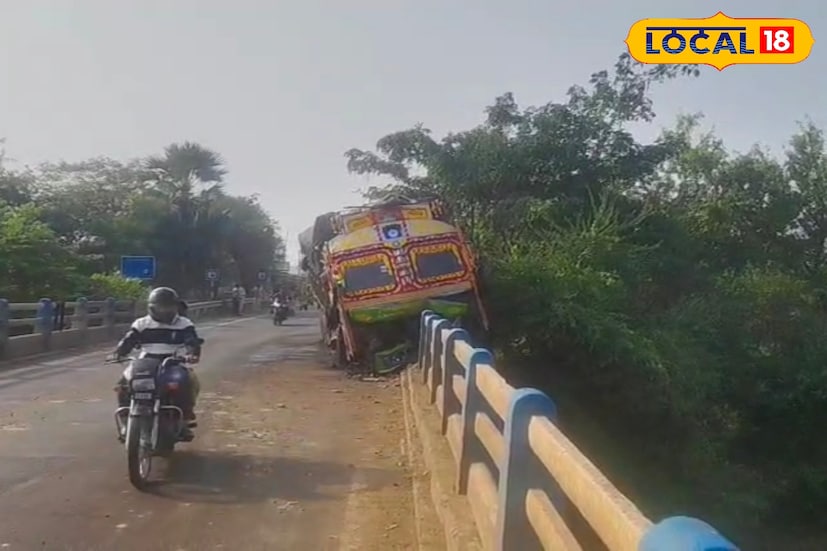 মুর্শিদাবাদ জেলার অন্যতম ব্যস্ততম সড়ক ফরাক্কা হলদিয়ার এই বাদশাহি সড়ক। উত্তরবঙ্গের সঙ্গে দক্ষিণবঙ্গের যোগাযোগের অন্যতম বিকল্প সড়ক পথ। তবে কালভার্টের মধ্যে এই ভাবে ঝুলন্ত অবস্থায় পণ্য বোঝাই লরি থাকতে দেখে আতঙ্কিত গ্রামের বাসিন্দারা। (ছবি ও তথ্য: কৌশিক অধিকারী)