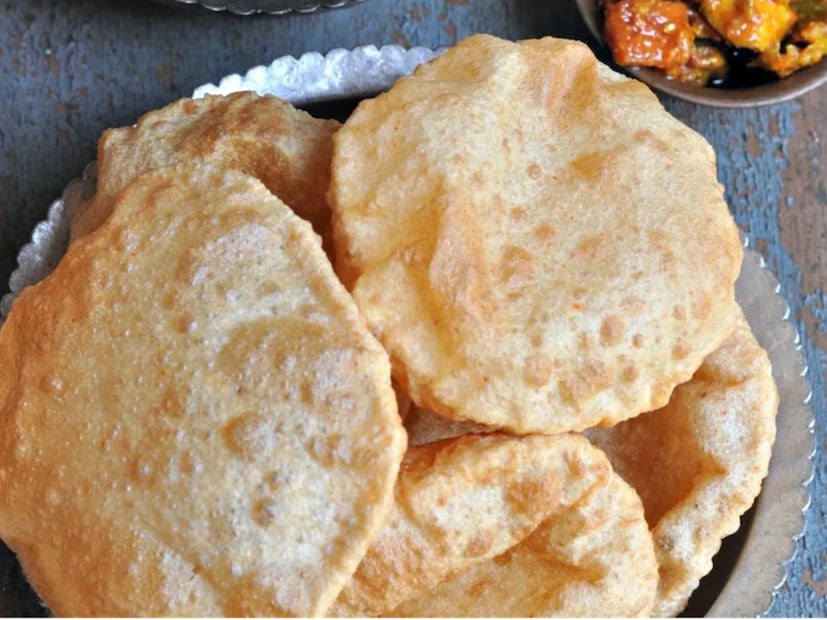 এবার একটা প্রেশার কুকার নিতে হবে। প্লেট রাখতে হবে তার ভিতরে। এমনভাবে সাজাতে হবে যাতে কুকারের পাত্রের নীচের অংশে জল গরম থাকে। তারপর ঢাকনা বন্ধ করে পাঁচ থেকে চার মিনিট ধরে কম আঁচে রান্না করতে হবে।  এখন রান্না করা লুচিগুলো একে একে বের করে পাত্রে রাখতে হবে। জুড়িয়ে গেলে একে একে এয়ার ফ্রায়ারে দিতে হবে, ঢাকনা বন্ধ করে প্রায় ১০০ ডিগ্রি সেলসিয়াস তাপমাত্রায় ৩০ সেকেন্ডের জন্য রেখে দিতে হবে। ৩০ সেকেন্ড পর ঠিক তেলে ভাজার মতোই লুচি পাওয়া যাবে, তফাত বোঝাই যাবে না! (Disclaimer: প্রতিবেদনের লেখা তথ্য News18 বাংলার নিজস্ব মত নয় ৷ সঠিক ফল পাওয়ার জন্য বিশেষজ্ঞের সঙ্গে যোগাযোগ করুন ৷ )