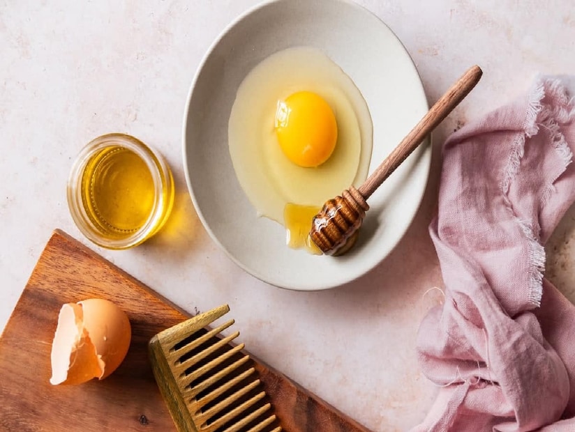 হেয়ার মাস্ক কীভাবে বানাবেন? একটি পাত্রে ২ টেবিল চামচ নারকেল তেল এবং ১ টেবিল চামচ জলপাই তেল নিন। এর মধ্যে একটি ডিমের সাদা অংশ, ১ টেবিল চামচ মধু এবং ২ টেবিল চামচ দই মেশান। সব উপকরণ ভালভাবে মিশিয়ে একটি ঘন মিশ্রণ তৈরি করুন।