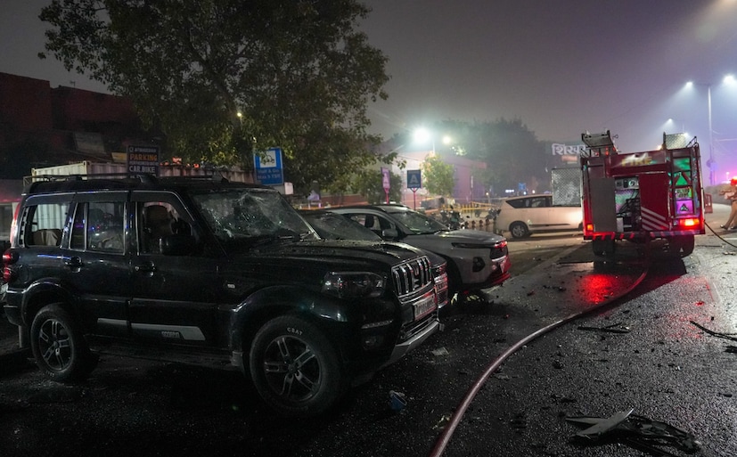 সোমবার রাতের দিল্লির লাল কেল্লা মেট্রো স্টেশনের গেট নম্বর ১-এর কাছে বিস্ফোরণ৷ প্রাথমিক তদন্তে ধারণা করা হচ্ছে যে বিস্ফোরণটি একটি ইকো ভ্যান থেকে শুরু হয়েছিল। তবে, বিস্ফোরণটি কাছাকাছি পার্ক করা একটি স্কুটার এবং একটি অটোরিকশাতেও আগুন ধরে যায়, যার ফলে বেশ কয়েকটি যানবাহন ক্ষতিগ্রস্ত হয়। (Photo Courtesy PTI) 