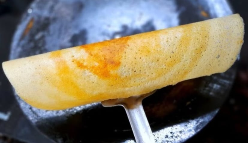 তেল/ঘি: ডোসা রাখার পর, এর চারপাশে সামান্য তেল বা ঘি লাগান। কম আঁচে রান্না করুন যতক্ষণ না ডোসা সম্পূর্ণ সোনালি বাদামী হয়ে যায়। এটি উল্টানোর দরকার নেই।