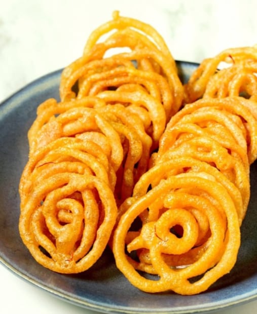 পুরুলিয়া: জিলিপি তো অনেক খেয়েছেন, কিন্তু পুরুলিয়ার এই বিশেষ জিলিপি খেয়েছেন কখনও ? পুরুলিয়ার কাশীপুরের ডমনকিয়ারি মোড়ের বিখ্যাত 'বিউলির জিলিপি।' সাধারণ জিলিপির থেকে এই জিলিপির স্বাদ যেমন সম্পূর্ণ আলাদা, তেমনই দেখতে ও গন্ধেও একেবারে অনন্য। বিউলির বেসন, চালের গুঁড়ো, রুল ময়দা ও চিনির নিখুঁত মিশ্রণে তৈরি এই বিশেষ জিলিপি প্রায় দুই দশক ধরে অসংখ্য মানুষের স্বাদের রাজত্ব করে আসছে। (শান্তনু দাস) (file photo)