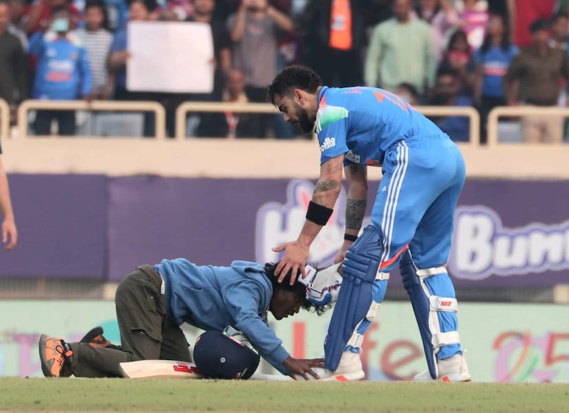 রবিবার রাঁচিতে ভারত বনাম দক্ষিণ আফ্রিকার ওয়ানডে ম্যাচে সেঞ্চুরি করেন বিরাট। তার পরেই দৌড়ে মাঠে ঢুকে পড়ে তাঁর পায়ে লুটিয়ে পড়েন এক ভক্ত।জানা গিয়েছে, বিরাট কোহলির সেই ভক্ত আসলে আরামবাগের পুরশুড়ার বাসিন্দা। নাম শৌভিক মুর্মু। আপাতত রাঁচি পুলিশ তাঁকে আটক করে রেখেছে। প্রিয় ক্রিকেটারকে একটিবার ছুঁয়ে দেখার জন্য বারবার চেষ্টা করেছেন পুরশুড়ার এই যুবক। তাঁর বাড়ি কাবলের মধুপুর আদিবাসী পাড়ায়।