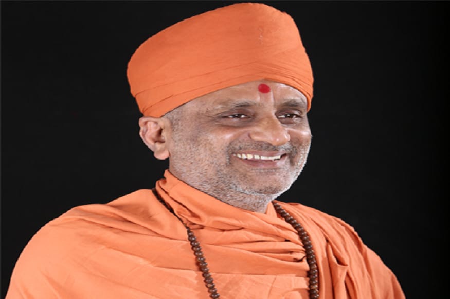 ભગવાન ક્યાં રહે છે? પ્રથમ પ્રશ્નનો જવાબ - સ્વામી હરિસ્વરૂપદાસજીએ પોતાની કથામાં હવે આ પ્રથમ પ્રશ્નના જવાબની વાત કરતા કહ્યું કે પંડિતજી દીકરાની સાથે રાજદરબારમાં જાય છે. પંડિતજી રાજાને કહે છે, આવા સામાન્ય પ્રશ્નનો જવાબ હું શું આપું, તે તો મારો દીકરો જ તમને જણાવી દેશે. હવે પંડીતજીનો દીકરો રાજાને કહે છે જો તમારે જ્ઞાન લેવું હોય તો રાજ સિંહાસન પરથી નીચે ઉતરી જમીન પર બેસવું પડશે, અને મને થોડી વાર માટે તમારા સિંહાસન પર બેસવા દેવો પડશે. રાજા તરત બ્રાહ્મણ દીકરાની વાત માની લે છે અને જ્ઞાન પ્રાપ્ત કરવા માટે પોતાના સિંહાસન પર થોડી વાર તેને બેસવા માટે મોકલે છે, અને પોતે નીચે જમીન પર બેસી જાય છે. હવે પંડીતજીનો દીકરો સિંહાસન પર બેસતા જ, સેવકો પાસે દુધનો એક ગ્લાસ મંગાવે છે અને રાજાને પોતાનો પ્રશ્ન કરવા જણાવે છે. રાજાએ પ્રથમ પ્રશ્ન પુછ્યો - ભગવાન ક્યાં રહે છે? તેમનું સરનામું શું છે? - હવે પંડીતજીનો પુત્ર રાજાને જવાબ આપવા રાજાને પ્રશ્ન પુછે છે - આ દૂધનો ગ્લાસ છે. દૂધમાં માખણ હોય છે? રાજા કહે છે - હા, હવે તમે મને કહો દૂધમાં માખણ ક્યાં રહે છે? હવે રાજા મુંઝાયા - તેમણે જવાબ આપ્યો દૂધના કણે કણમાં માખણ હોય છે. પંડીતજીના દીકરાએ તુરંત રાજાને કહ્યું તમારા પહેલા પ્રશ્નનો જવાબ આજ છે. જેમ દૂધમાં માખણ કણે કણમાં છે, તેમ ભગવાન પણ કણે કણમાં રહે છે. રાજાને પ્રશ્નનો જવાબ સંતોષકારક મળી ગયો. ભગવાન ક્યાં રહે છે? પ્રથમ પ્રશ્નનો જવાબ - સ્વામી હરિસ્વરૂપદાસજીએ પોતાની કથામાં હવે આ પ્રથમ પ્રશ્નના જવાબની વાત કરતા કહ્યું કે પંડિતજી દીકરાની સાથે રાજદરબારમાં જાય છે. પંડિતજી રાજાને કહે છે, આવા સામાન્ય પ્રશ્નનો જવાબ હું શું આપું, તે તો મારો દીકરો જ તમને જણાવી દેશે. હવે પંડીતજીનો દીકરો રાજાને કહે છે જો તમારે જ્ઞાન લેવું હોય તો રાજ સિંહાસન પરથી નીચે ઉતરી જમીન પર બેસવું પડશે, અને મને થોડી વાર માટે તમારા સિંહાસન પર બેસવા દેવો પડશે. રાજા તરત બ્રાહ્મણ દીકરાની વાત માની લે છે અને જ્ઞાન પ્રાપ્ત કરવા માટે પોતાના સિંહાસન પર થોડી વાર તેને બેસવા માટે મોકલે છે, અને પોતે નીચે જમીન પર બેસી જાય છે. હવે પંડીતજીનો દીકરો સિંહાસન પર બેસતા જ, સેવકો પાસે દુધનો એક ગ્લાસ મંગાવે છે અને રાજાને પોતાનો પ્રશ્ન કરવા જણાવે છે. રાજાએ પ્રથમ પ્રશ્ન પુછ્યો - ભગવાન ક્યાં રહે છે? તેમનું સરનામું શું છે? - હવે પંડીતજીનો પુત્ર રાજાને જવાબ આપવા રાજાને પ્રશ્ન પુછે છે - આ દૂધનો ગ્લાસ છે. દૂધમાં માખણ હોય છે? રાજા કહે છે - હા, હવે તમે મને કહો દૂધમાં માખણ ક્યાં રહે છે? હવે રાજા મુંઝાયા - તેમણે જવાબ આપ્યો દૂધના કણે કણમાં માખણ હોય છે. પંડીતજીના દીકરાએ તુરંત રાજાને કહ્યું તમારા પહેલા પ્રશ્નનો જવાબ આજ છે. જેમ દૂધમાં માખણ કણે કણમાં છે, તેમ ભગવાન પણ કણે કણમાં રહે છે. રાજાને પ્રશ્નનો જવાબ સંતોષકારક મળી ગયો.