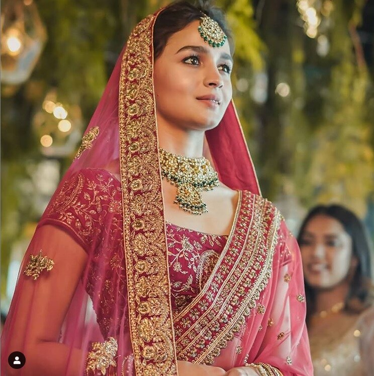 આલિયાએ આ સુંદર દુલ્હન જોડાની સાથે ગોલ્ડન અને ગ્રીન રંગનો હાર અને ટીકો પહેર્યો છે. તેને કાનમાં કંઇ જ પહેર્યું નથી. જોકે તે ખુબજ સુદંર લાગી રહી છે. (Photo: Instagram) આલિયાએ આ સુંદર દુલ્હન જોડાની સાથે ગોલ્ડન અને ગ્રીન રંગનો હાર અને ટીકો પહેર્યો છે. તેને કાનમાં કંઇ જ પહેર્યું નથી. જોકે તે ખુબજ સુદંર લાગી રહી છે. (Photo: Instagram)