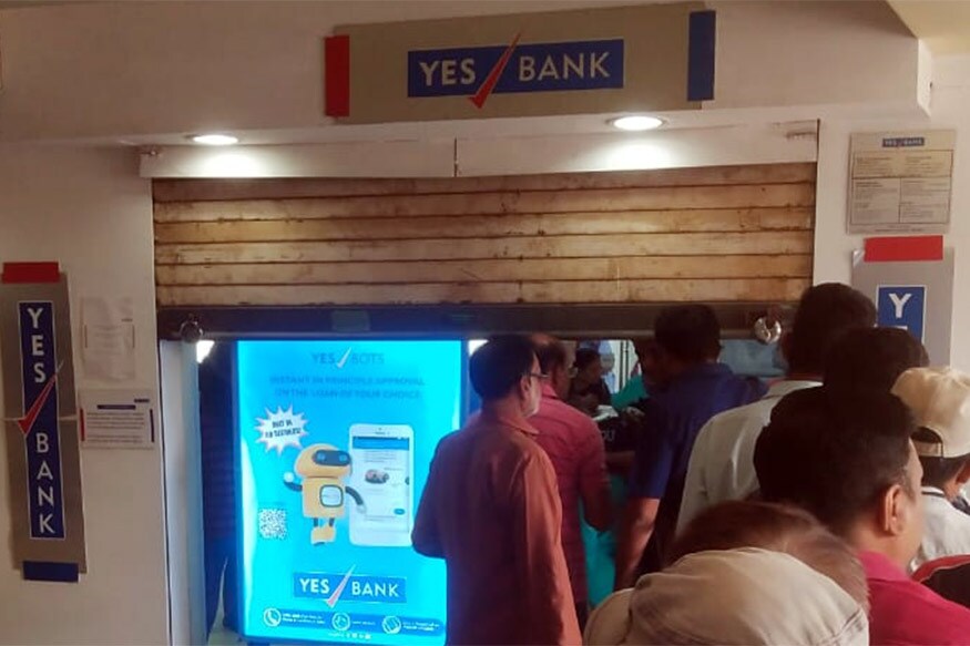 અંકિત પોપટ, રાજકોટ : ગુરુવારની સાંજે આરબીઆઇ (Reserve Bank of India)એ જાહેરાત કરી હતી કે યસ બેંક (Yes Bank Account Holder)ના ખાતાધારકો પોતાના ખાતામાંથી 50,000 રૂપિયા (Cash Withdrawal) જેટલી જ રકમ ઉપાડી શકશે. આરબીઆઇની જાહેરાત બાદ રાજકોટ સહિત સમગ્ર દેશની અંદર યસ બેન્કના એટીએમ (Yes Bank ATM) સેન્ટર બહાર ખાતાધારકોની (Yes Bank Account Holder)લાંબી કતારો જોવા મળી હતી. આ જ પ્રકારની લાંબી કતારો શુક્રવારે રાજકોટ (Rajkot)માં જોવા મળી રહી છે. જે રીતે આરબીઆઇ દ્વારા નિર્ણય લેવામાં આવ્યો છે તેનાથી લોકોમાં રોષ ફેલાયો છે. અંકિત પોપટ, રાજકોટ : ગુરુવારની સાંજે આરબીઆઇ (Reserve Bank of India)એ જાહેરાત કરી હતી કે યસ બેંક (Yes Bank Account Holder)ના ખાતાધારકો પોતાના ખાતામાંથી 50,000 રૂપિયા (Cash Withdrawal) જેટલી જ રકમ ઉપાડી શકશે. આરબીઆઇની જાહેરાત બાદ રાજકોટ સહિત સમગ્ર દેશની અંદર યસ બેન્કના એટીએમ (Yes Bank ATM) સેન્ટર બહાર ખાતાધારકોની (Yes Bank Account Holder)લાંબી કતારો જોવા મળી હતી. આ જ પ્રકારની લાંબી કતારો શુક્રવારે રાજકોટ (Rajkot)માં જોવા મળી રહી છે. જે રીતે આરબીઆઇ દ્વારા નિર્ણય લેવામાં આવ્યો છે તેનાથી લોકોમાં રોષ ફેલાયો છે.