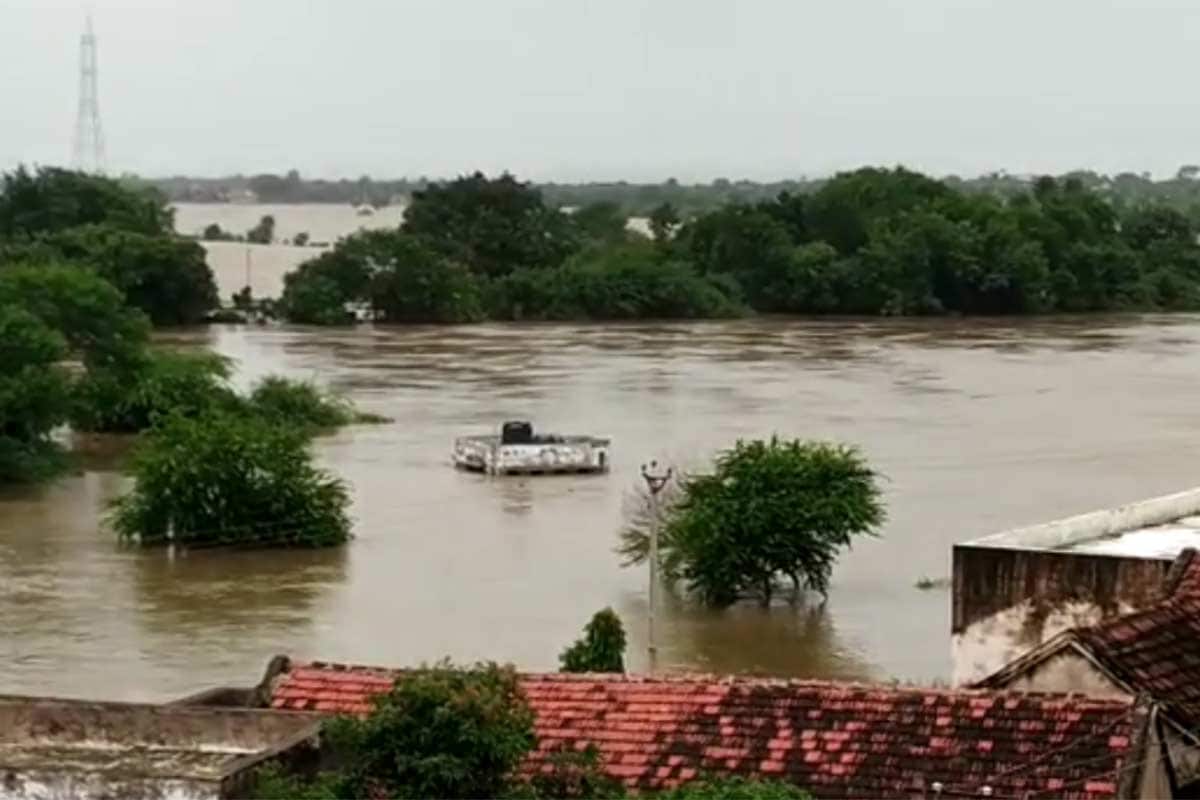 જામનગર : આ વખતે સૌરાષ્ટ્ર પર મેઘરાજાએ વિશેષ હેત વરસાવ્યું છે. અહીં અત્યાર સુધી લગભગ સિઝનનો 100 ટકા વરસાદ પડી ગયો છે. તેમાં પણ દેવભૂમિ દ્વારાકાના અમુક વિસ્તારોમાં ભારે વરસાદથી ખેડૂતો અને અનેક ગામડાઓએ હાલાકી ભોગવવી પડી છે. વર્તુ-2 ડેમમાંથી પાણી છોડવામાં આવતા કલ્યાણપુર તાલુકાનું જામ રાવલ અને તેની આસપાસના ગામો ફરી એકવાર બેટમાં ફેરવાયા છે. હાલત એવી છે કે ગામમાં જવા માટે બોટનો સહારો લેવો પડી રહ્યો છે. છેલ્લા દોઢ મહિનામાં ચોથી વખત અહીં આવી હાલત થઈ છે. જામનગર : આ વખતે સૌરાષ્ટ્ર પર મેઘરાજાએ વિશેષ હેત વરસાવ્યું છે. અહીં અત્યાર સુધી લગભગ સિઝનનો 100 ટકા વરસાદ પડી ગયો છે. તેમાં પણ દેવભૂમિ દ્વારાકાના અમુક વિસ્તારોમાં ભારે વરસાદથી ખેડૂતો અને અનેક ગામડાઓએ હાલાકી ભોગવવી પડી છે. વર્તુ-2 ડેમમાંથી પાણી છોડવામાં આવતા કલ્યાણપુર તાલુકાનું જામ રાવલ અને તેની આસપાસના ગામો ફરી એકવાર બેટમાં ફેરવાયા છે. હાલત એવી છે કે ગામમાં જવા માટે બોટનો સહારો લેવો પડી રહ્યો છે. છેલ્લા દોઢ મહિનામાં ચોથી વખત અહીં આવી હાલત થઈ છે.