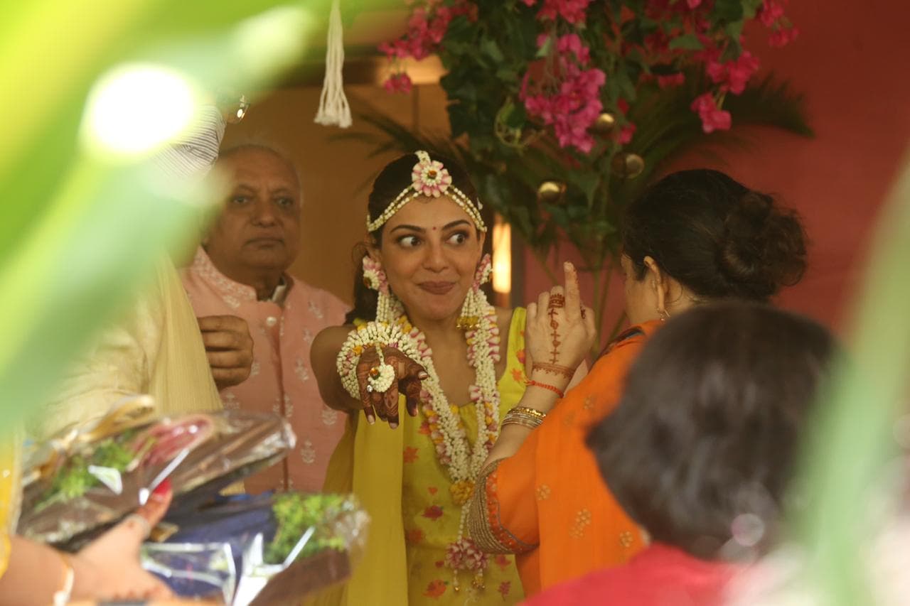 હાલમાં જ કાજલ અગ્રવાલની મેંહદી સેરેમનીની કેટલીક તસવીરો વાયરલ થઇ રહી છે. આ ફોટોમાં તેની આસપાસ ઘણાં બધા પરિવારનાં લોકો નજર આવી રહ્યાં છે. કાજલ પીળા રંગનાં ડ્રેસમાં નજર આવે છે તેણે સફેદ અને લાલ ફૂલોની જ્વેલરી પહેરી છે. આ તસવીરોમાં તે ખુબજ સુંદર લાગે છે. (Photo Credit- Viral Bhayani) હાલમાં જ કાજલ અગ્રવાલની મેંહદી સેરેમનીની કેટલીક તસવીરો વાયરલ થઇ રહી છે. આ ફોટોમાં તેની આસપાસ ઘણાં બધા પરિવારનાં લોકો નજર આવી રહ્યાં છે. કાજલ પીળા રંગનાં ડ્રેસમાં નજર આવે છે તેણે સફેદ અને લાલ ફૂલોની જ્વેલરી પહેરી છે. આ તસવીરોમાં તે ખુબજ સુંદર લાગે છે. (Photo Credit- Viral Bhayani)