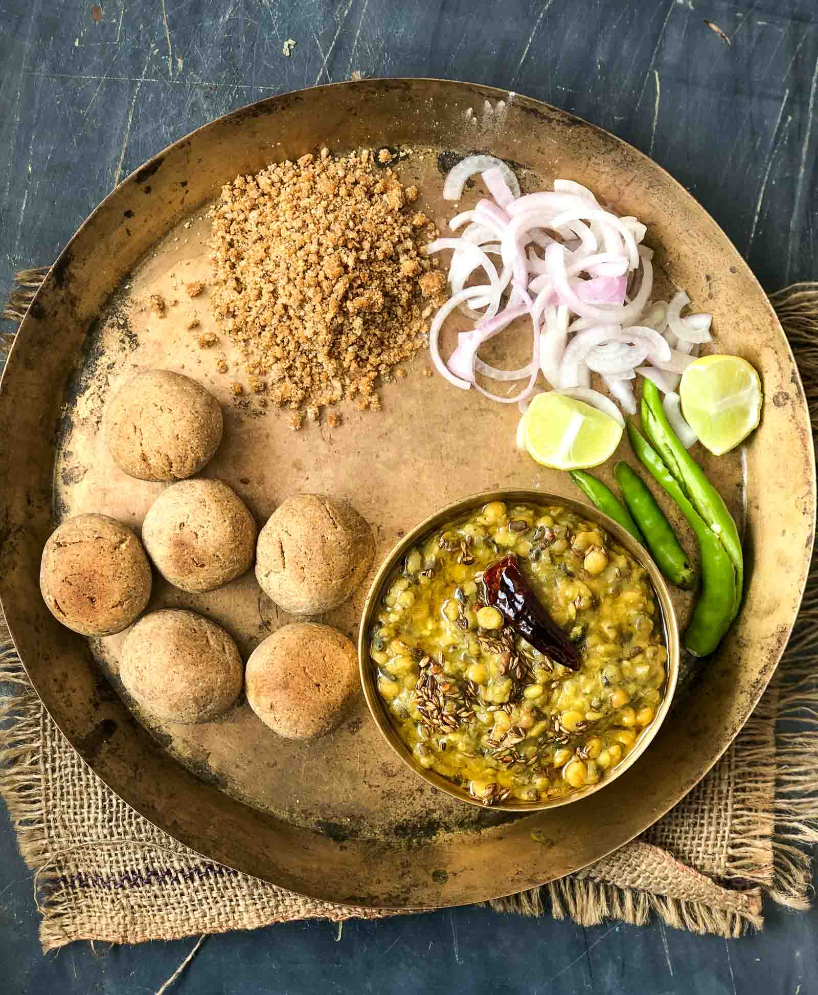 બાટી બનાવવાની રીત - લોટ અને રવાને એક વાસણમાં મિક્સ કરી લો એમાં 3 ચમચી ઘી , બેકિંગ સોડા અજમો, જીરૂ અને મીઠું નાખી મિક્સ કરો. હૂંફાણા પાણીની સહાયતાથી લોટને રોટલીના લોટથી થોડું ટાઈટ બાંધી લો. લોટને 20 મિનિટ માટે ઢાંકીને મૂકી દો. જેથી લોટ ફૂલીને સેટ થઈ જાય. 20 મિનિટ પછી આ લોટને તેલના હાથથી મસળીને ચિકણો કરી લો. બાંધેલા લોટથી થોડું લોટ લઈને એમના ગોળ ગોલા બનાવી લો. હવે તંદૂરને ગરમ કરો. તંદૂરમાં લોટની બનાવેલા એ ગોળા શેકવા માટે રાખો. આ ગોળાને તંદૂરમાં પલટી-પલટીને શેકો. બાટી ફટવા લાગશે અને બ્રાઉન થઈ જશે . શેકેલી બાટીને પ્લેટમાં રાખી લો. હવે શેકેલી બાટીને વચ્ચેથી ફોડીને ઘી માં ડુબાડીને કાઢી લો. બાટી બનાવવાની રીત - લોટ અને રવાને એક વાસણમાં મિક્સ કરી લો એમાં 3 ચમચી ઘી , બેકિંગ સોડા અજમો, જીરૂ અને મીઠું નાખી મિક્સ કરો. હૂંફાણા પાણીની સહાયતાથી લોટને રોટલીના લોટથી થોડું ટાઈટ બાંધી લો. લોટને 20 મિનિટ માટે ઢાંકીને મૂકી દો. જેથી લોટ ફૂલીને સેટ થઈ જાય. 20 મિનિટ પછી આ લોટને તેલના હાથથી મસળીને ચિકણો કરી લો. બાંધેલા લોટથી થોડું લોટ લઈને એમના ગોળ ગોલા બનાવી લો. હવે તંદૂરને ગરમ કરો. તંદૂરમાં લોટની બનાવેલા એ ગોળા શેકવા માટે રાખો. આ ગોળાને તંદૂરમાં પલટી-પલટીને શેકો. બાટી ફટવા લાગશે અને બ્રાઉન થઈ જશે . શેકેલી બાટીને પ્લેટમાં રાખી લો. હવે શેકેલી બાટીને વચ્ચેથી ફોડીને ઘી માં ડુબાડીને કાઢી લો.