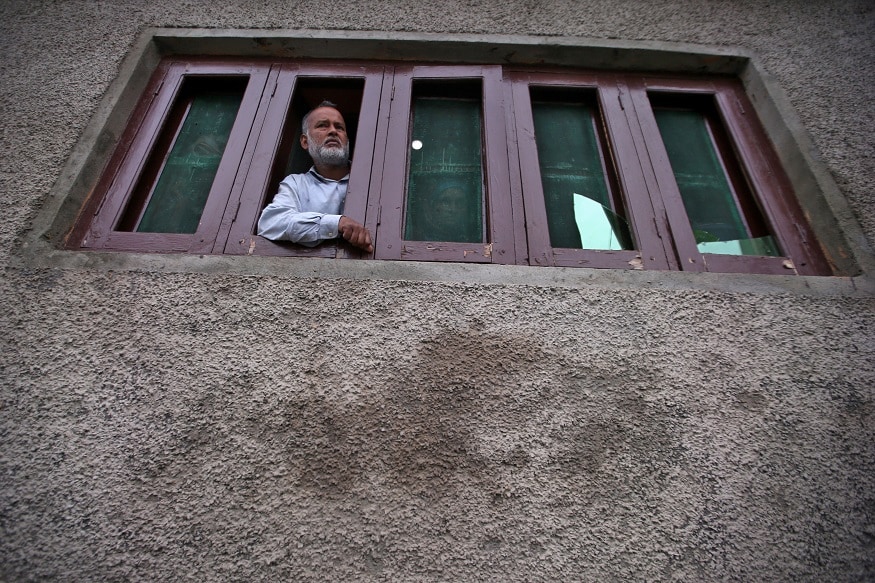 ایک کشمیری شہری اپنے مکان میں باہر کا نظارہ کرتے ہوئے۔(تصویر:رائٹرز)۔