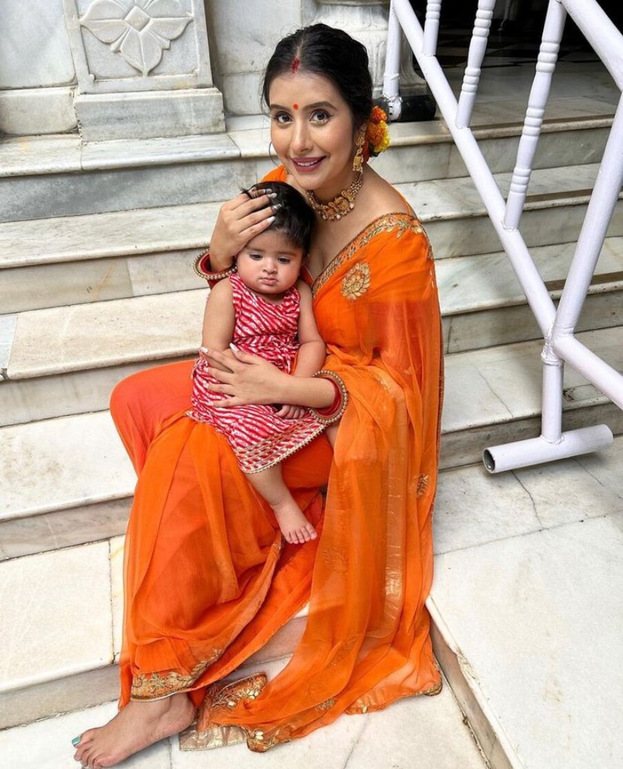  تصاویر میں چارو اسوپا نے نارنجی رنگ کی ساڑھی پہنی ہوئی ہے اور وہ اپنی بیٹی کے ساتھ مندر کی سیڑھیوں پر بیٹھی نظر آ رہی ہیں۔ (فوٹو کریڈٹ: انسٹاگرام: @asopacharu)