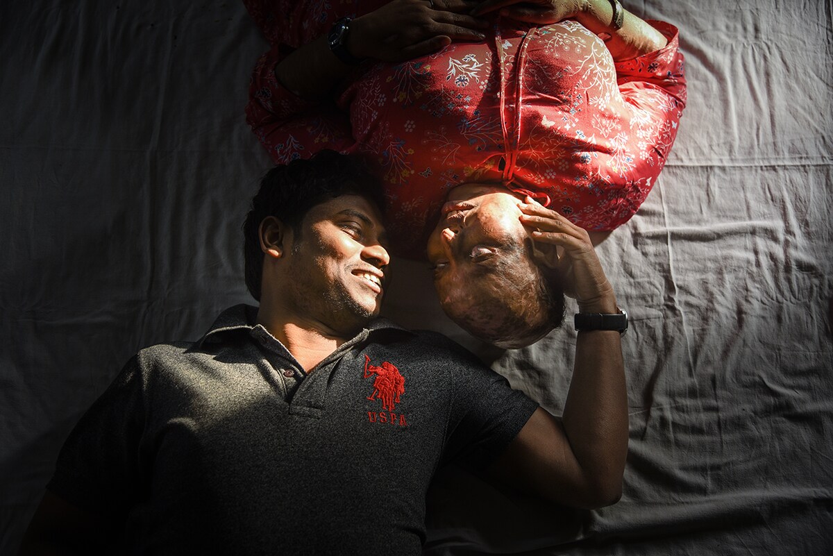 Couple lying on the bed and looking into each other's eyes. 