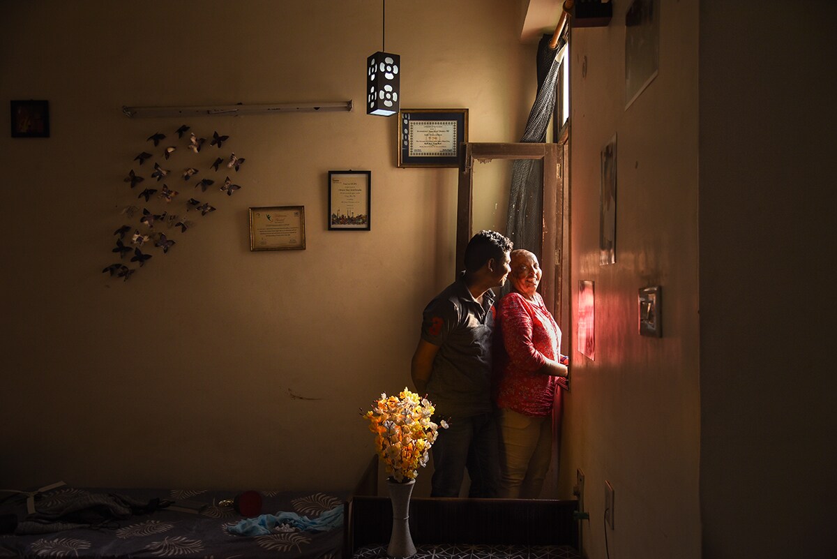 Saroj and Rani standing by the window in a happy mood.