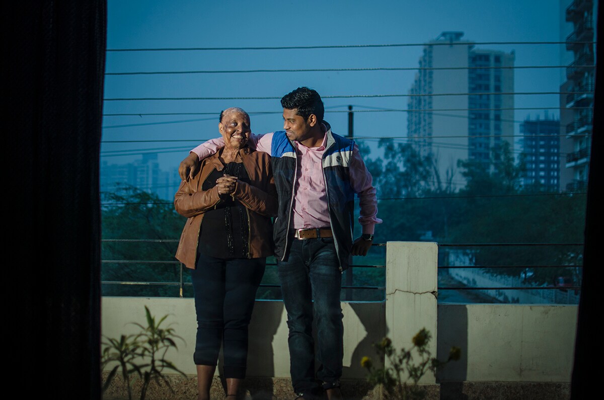 Couple enjoying a romantic evening on the balcony, embracing, smiling. 