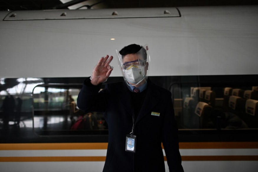 A railway employee gestures as passengers arrive at the train station in Wuhan after travel restrictions into the city were eased following two months of lockdown due to the COVID-19 coronavirus outbreak. (Image: AFP) A railway employee gestures as passengers arrive at the train station in Wuhan after travel restrictions into the city were eased following two months of lockdown due to the COVID-19 coronavirus outbreak. (Image: AFP)