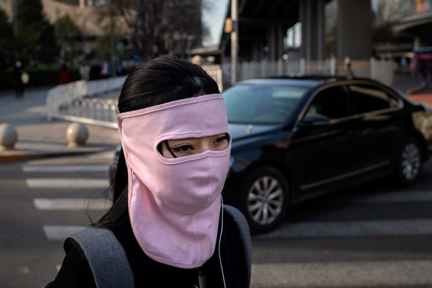 A woman wearing a face mask amid the COVID-19 coronavirus outbreak walks outside office buildings in Beijing. (Image: AFP) A woman wearing a face mask amid the COVID-19 coronavirus outbreak walks outside office buildings in Beijing. (Image: AFP)