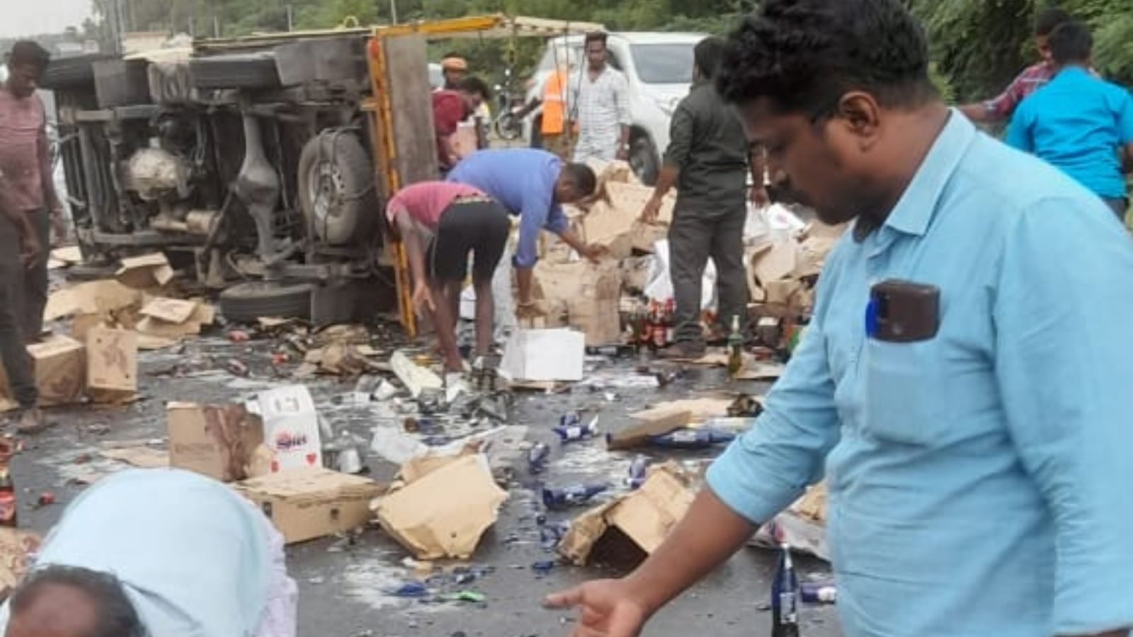 மதுபானங்களை ஏற்றி வந்த சரக்கு வேன் கவிழ்ந்து விபத்து.. போட்டி போட்டுக்கொண்டு அள்ளிச்சென்ற மதுப்பிரியர்கள்