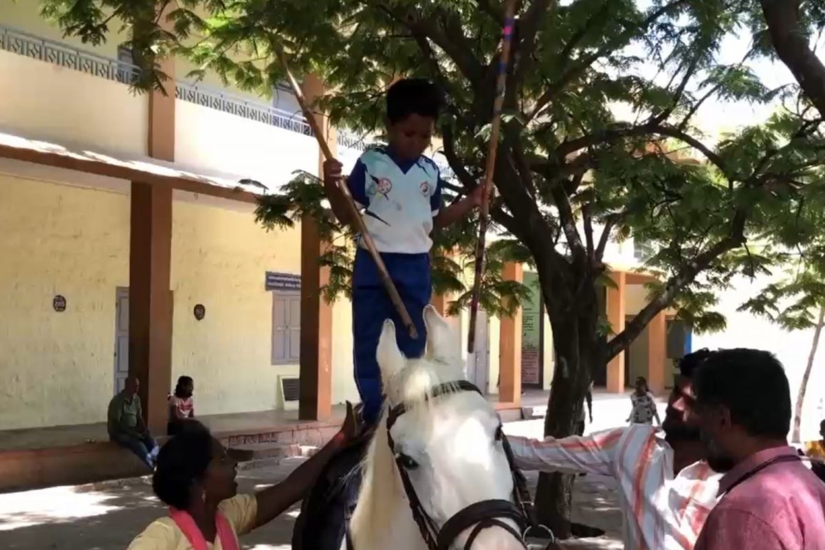குதிரை மேல் நின்று சிலம்பம் சுற்றிய சிறுவன்