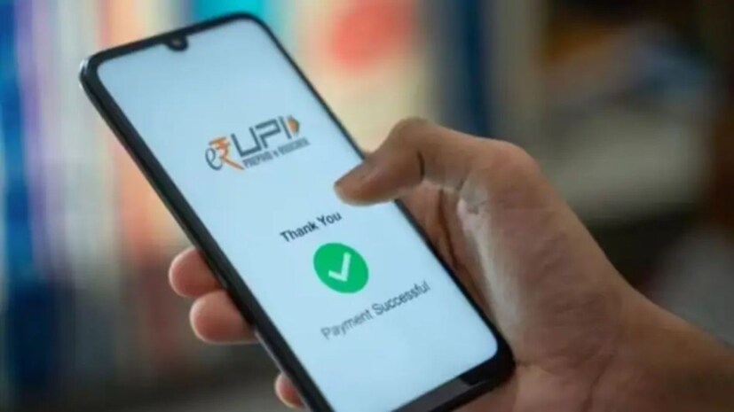  UPI விதி:<br />UPI மோசடியைக் குறைப்பதற்காக NPCI புதிய விதிகளைச் செயல்படுத்தத் திட்டமிட்டுள்ளது. இந்தப் புதிய விதிகளின்படி, ஜூன் 30, 2025 முதல், அனைத்து UPI செயலிகளும் பணம் செலுத்துவதற்கு முன்பு, வங்கியில் பதிவுசெய்யப்பட்ட உண்மையான பயனாளியின் பெயரை மட்டுமே காண்பிக்க வேண்டும். அதாவது, QR குறியீடு, கைபேசி எண் அல்லது பயனர் குறிப்பிடும் பெயருக்குப் பதிலாக, நீங்கள் பணம் அனுப்பும் நபர் அல்லது வணிகரின் சரிபார்க்கப்பட்ட பெயர் இனி காண்பிக்கப்படும். இது போலிப் பெயர்களைப் பயன்படுத்தி செய்யப்படும் UPI மோசடியைக் குறைக்கும் என்றும், பணம் செலுத்துவதற்கு முன்பு உண்மையான நபரை அடையாளம் காண பயனர்களுக்கு உதவும் என்றும் எதிர்பார்க்கப்படுகிறது.