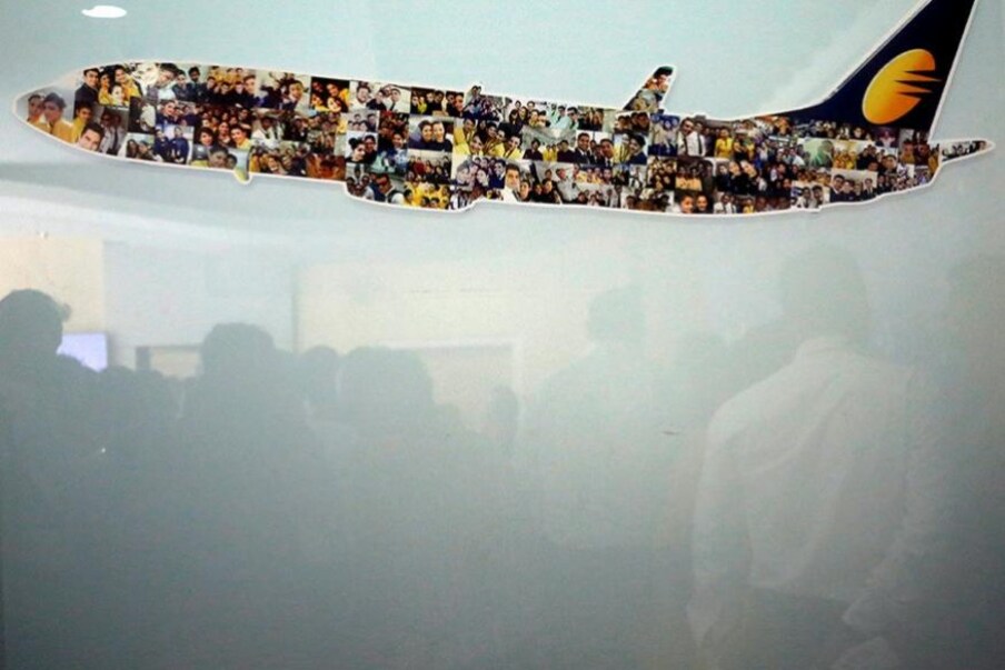  ముంబైలోని సంస్థ హెడ్ క్వార్టర్ దగ్గర గ్లాస్ విండోలో రిఫ్లెక్ట్ అవుతున్న జెట్ ఎయిర్‌వేస్ ఉద్యోగులు (Image: Reuters)