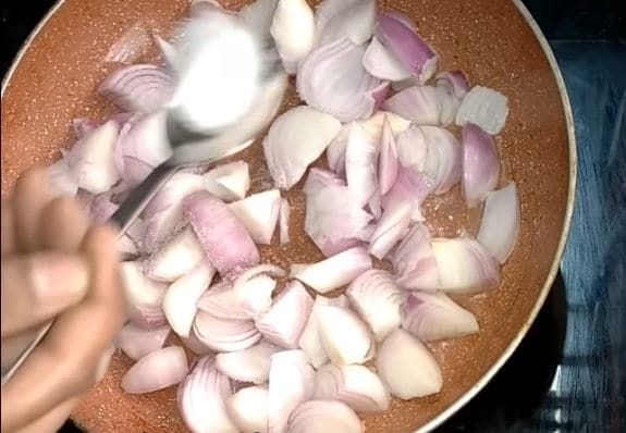  వెంటనే కొద్దిగా ఉప్పు వెయ్యాలి. కాసేపు ఉల్లి ముక్కల్ని వేపాలి. (image credit - youtube)