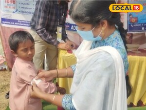 బాలుడికి స్టిక్కర్ వేస్తున్న సిబ్బంది 