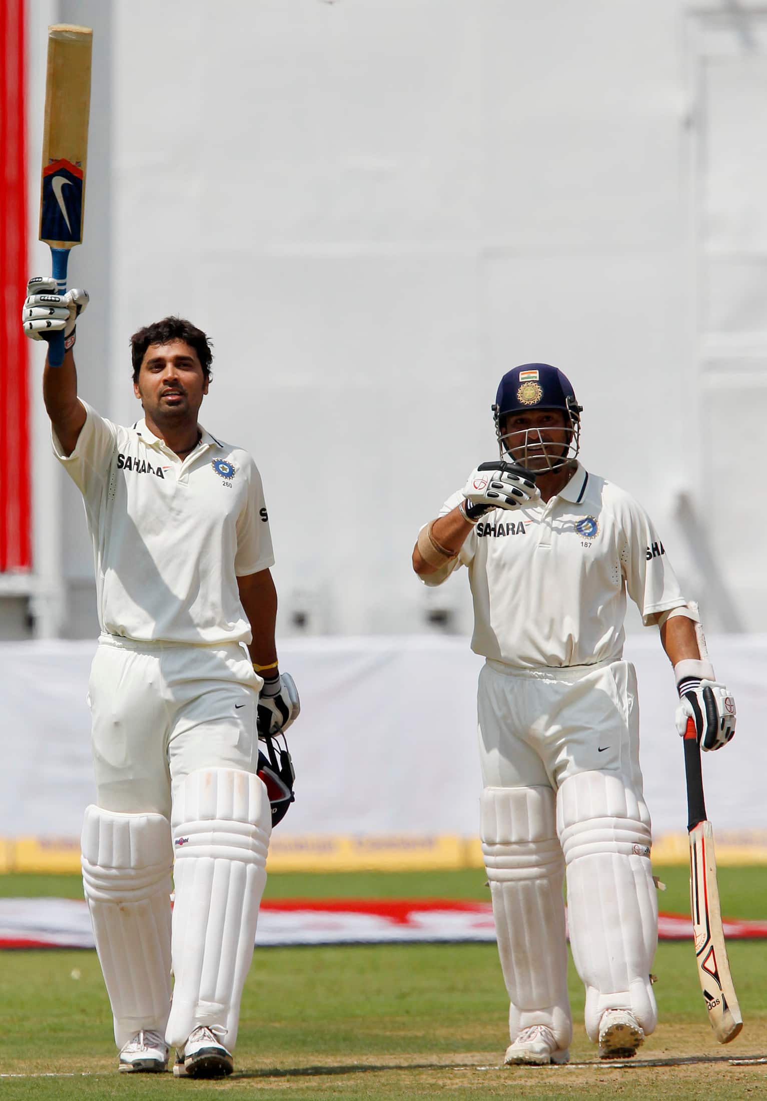 India's Murali Vijay celebrates his first test century next to teammate Sachin Tendulkar during the third day of their second test cricket match against Australia in Bangalore