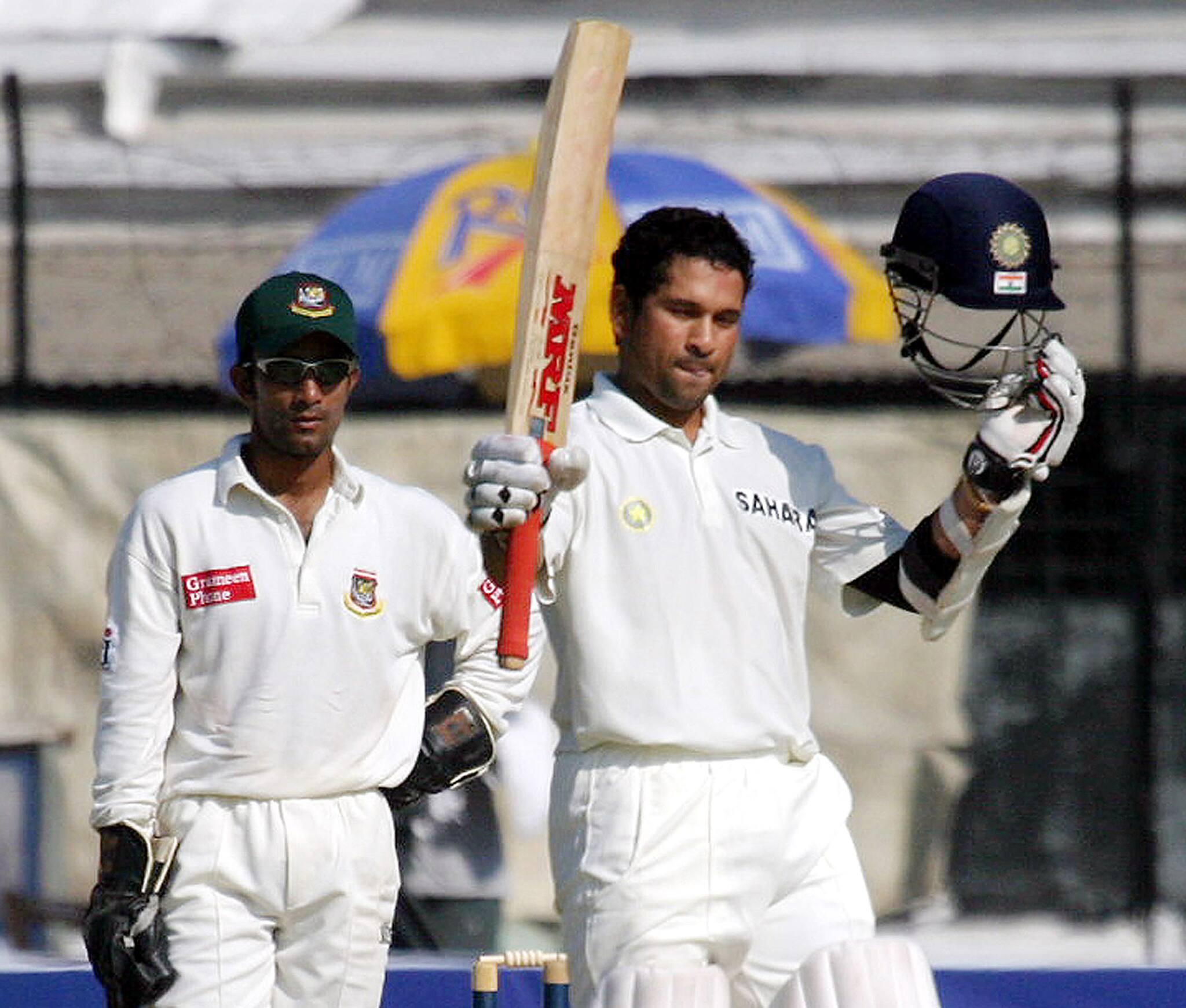 Indian batsman Sachin Tendulkar raises his bat and helmet after completing his double century ...